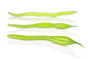 Group of three whole fresh green bean in row isolated on white background