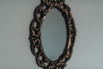 Vintage looking bronze plated mirror hanging on the wall