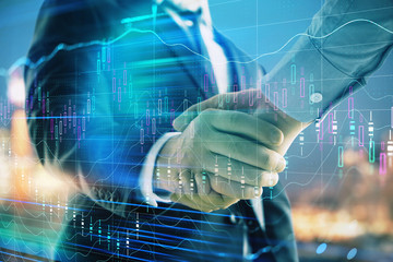 Double exposure of financial chart on cityscape background with two businessmen handshake. Concept of financial analysis and investment opportunities