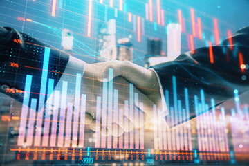 Fototapeta na wymiar Double exposure of financial graph on cityscape background with two businessman handshake. Concept of stock market deal