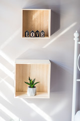 Mini love letters in the form of mini houses and mini aloe vera plant in a vasein a wooden box