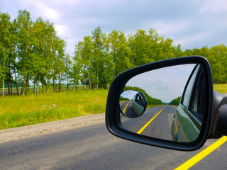 The insured car is a guarantee of safety. Traveling by car with the whole family. View through the car window to the rearview mirror.