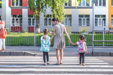 Back to school education concept with girl kids, elementary students, carrying backpacks going to class