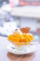 Fresh mango shaved ice with a scoop of ice cream and juice sauce in summer restaurant, lifestyle, popular food in Taiwan, close up.