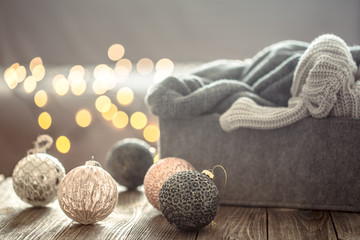 Christmas tree decorations over Christmas lights bokeh in home on wooden table with sweater on a background and decorations. Holiday decoration