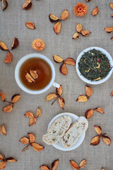 Herbal tea with dried flowers and peaches on sackcloth background.