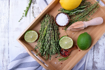 Fresh thyme, pepper peas, sea salt, lemon and lime on wooden tray. Ingredients for making marinade