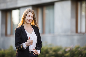 Young cheerful woman showing thumb up