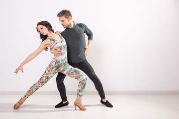 Social dance, kizomba, tango, salsa, people concept - beautiful couple dancing bachata on white...