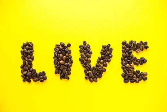 Coffee beens on yellow background. Word Food