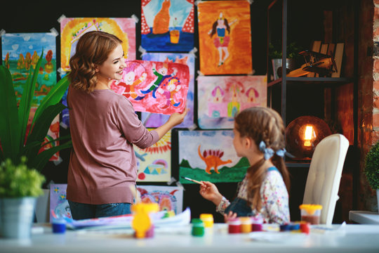 mother and child daughter painting draws in creativity in kindergarten