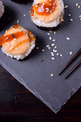 Close-up of sushi rolls wrapped in nori with spicy sauce. Top view
