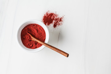 Super food beetroot powder in white bowl on a white background. Healthy eating concept.
