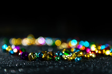 Colorful Christmas jingle bells. Black blurred background. Copy space.
