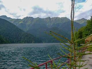 Abkhazia, the shore of the mountain lake Ritsa, mountains, forest, blue sky, white clouds