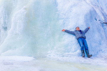 beautiful mature tourist by a frozen waterfall