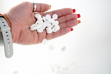 female with a handful of white pills