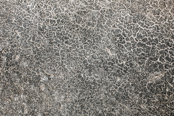 Dry cracked black asphalt texture. Old grunge road closeup macro background.