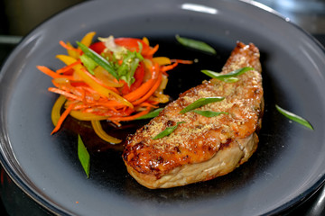 big steak on a round black plate