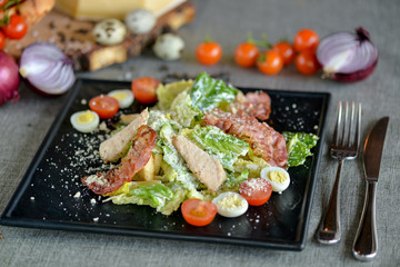 caesar salad on a square black plate