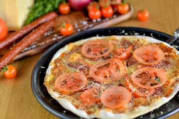 pizza with tomatoes and ksalah on a large dish in a restaurant on the table