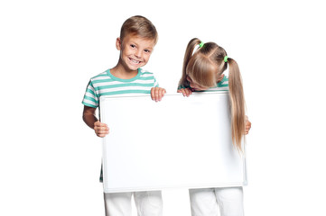 Little boy and girl are holding empty board, isolated on white background. Happy smiling children - brother and sister, with blank sign for text.