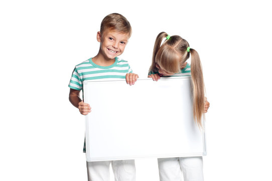 Little Boy And Girl Are Holding Empty Board, Isolated On White Background. Happy Smiling Children - Brother And Sister, With Blank Sign For Text.