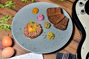 veal tartare with bread on a gray plate
