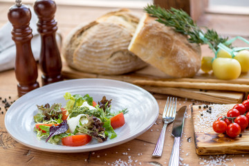 salad with sir and tomatoes on a round plate in a restaurant on the table