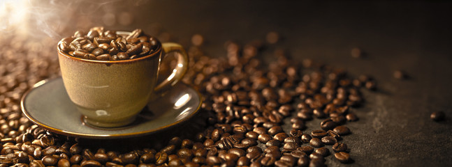 Tasse à café avec des grains sur un fond sombre