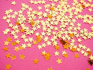 Golden stars glitter on pink background
