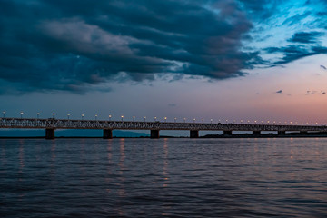 Obraz premium Bridge over the Amur river at sunset. Russia. Khabarovsk. Photo from the middle of the river.
