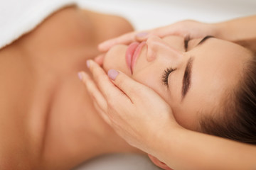 Fototapeta na wymiar Woman getting face massage at beauty salon, closeup