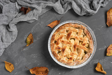 Flat lay of delicious pie surrounded by leaves