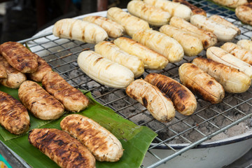 Grilled banana on grill charcoal brazier, tradition street food in Thailand