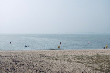 A picture of Tranquil summer beach on a slightly hazy day. 