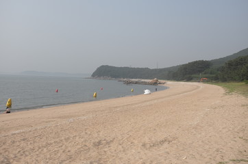 A picture of Tranquil summer beach on a slightly hazy day. 