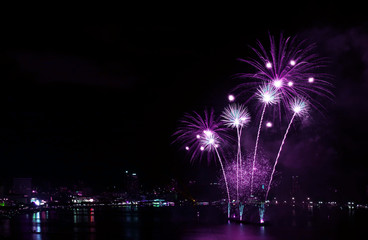 Impressive vivid purple color fireworks splashing in the night sky over the harbor
