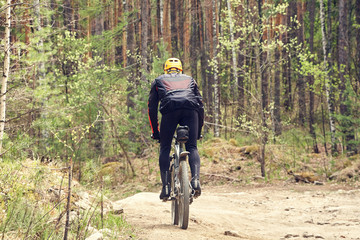 Naklejka premium cyclist riding a mountain bike along a forest road