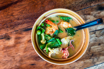 Seafood spicy noodle soup serve in clay bowl, Thai food.
