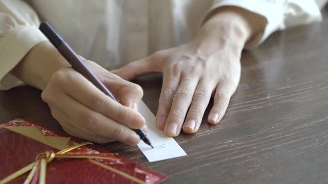 ご祝儀袋に記名する女性の手元