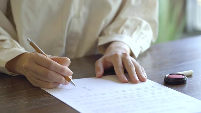 書類に記名する女性の手
