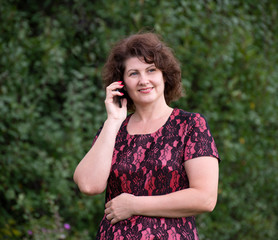 Woman in nature talking on a cell phone