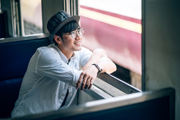 Asian man is traveler, he is waiting for their train. Outdoor adventure travel by train concept. Bangkok, Thailand. Happy/positive/healthy hike/travel/wanderlust concept