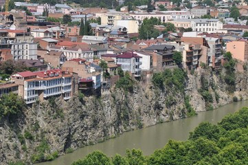 Fototapeta na wymiar Houses of the old district of Tbilisi, standing on the steep bank of the Kura River