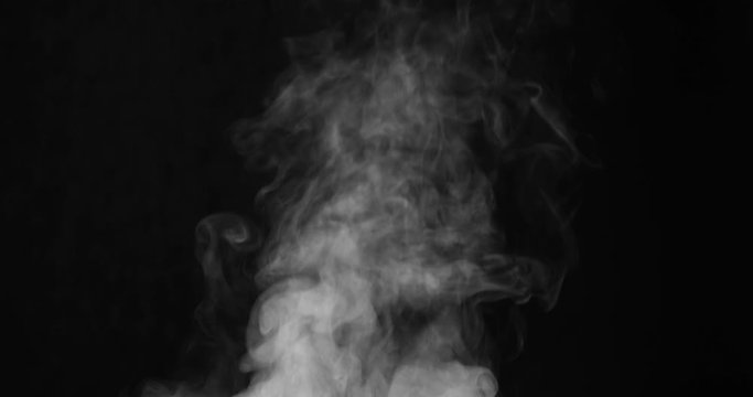 White Steam Ascends Over the Pan. White Steam rises from a large pot that is behind the scenes. Black background. Filmed at a speed of 120fps