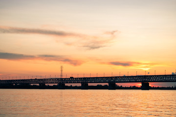 Naklejka na ściany i meble Bridge over the Amur river at sunset. Russia. Khabarovsk. Photo from the middle of the river.