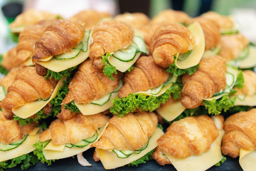 Delicious croissants sandwiches with fresh cucumber, cheese, hard boiled egg and salad. Closeup view - 282257631