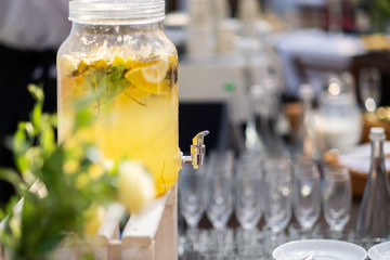 Glass jars of lemonade on wedding candy bar. Catering. Drinks on wedding party. Summer wedding in the forest - 282258010