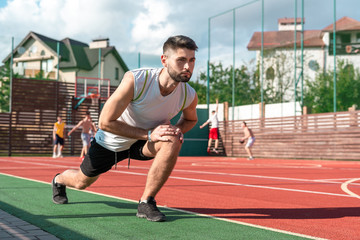 Fototapeta premium Men wearing sports clothes doing stretching workout outdoors.